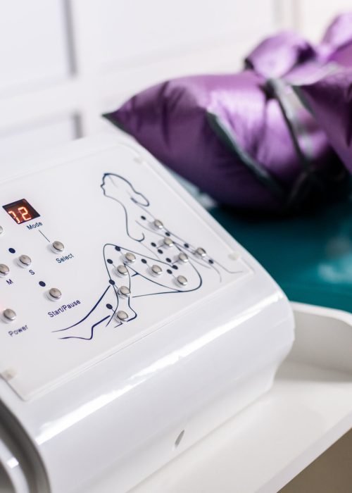 Apparatus of pressotherapy in beauty clinic. Cropped view of patient in violet suit. Concept of body care and beauty. Apparatus of pressotherapy in beauty clinic. Cropped view of patient in violet suit. Concept of body care and beauty. High quality photo