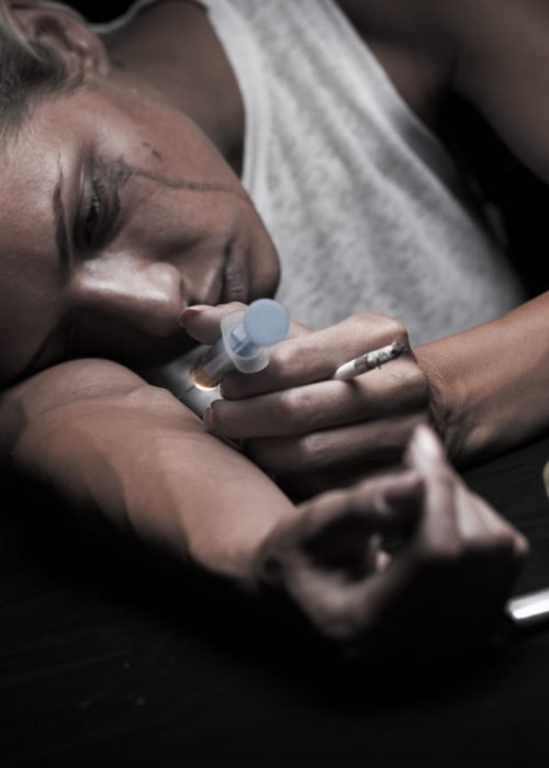 Young female drug addict on black background. Young female drug addict on black background.